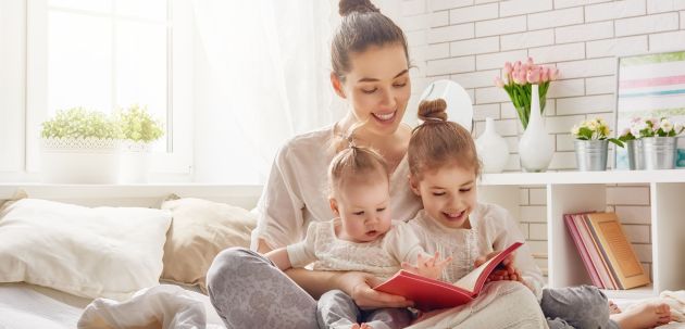 54018592 - happy loving family. pretty young mother reading a book to her daughters